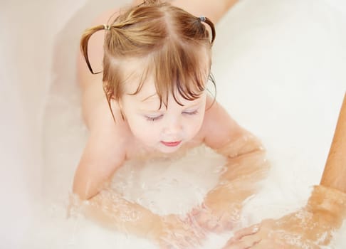 Kids, cleaning and water with a baby in the bathroom for childhood hygiene or natural skincare. Children, bath and a happy young toddler girl in a bathtub for health and wellness in her home.