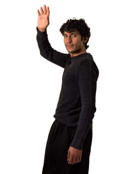 A man in a black shirt and black pants greeting with one hand, saluting raising his hand, in studio shot