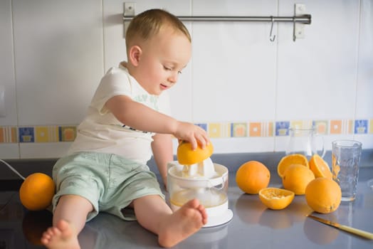 a girl child makes freshly squeezed orange juice on a manual juicer.