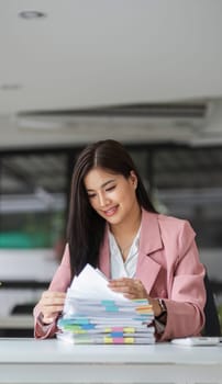 A happy businesswoman sits and checks her recently completed job information..