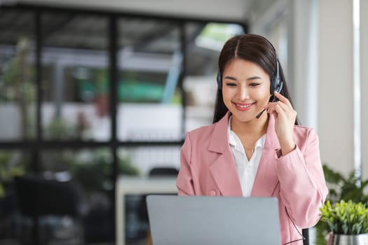 A call center operator is explaining job details to a customer on a laptop..