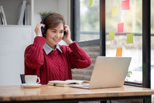 Asian female student study online in class, study online, wearing headphones, watching video call, zooming, happy asian female learning language online with computer laptop