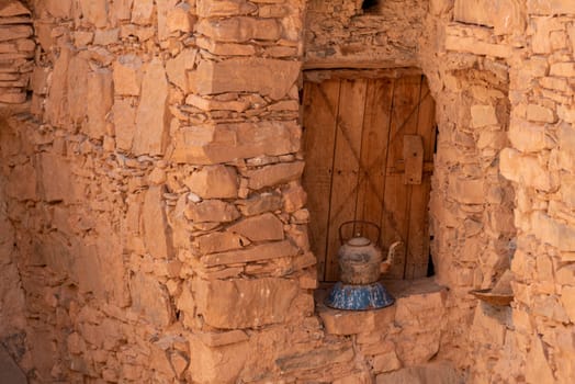 An old tea can in front of an antique window shutter of a berber house in Morocco