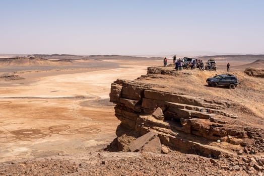 Tourists enjoying the scenic view of the Sahara desert from mount Gara Medouar, Morocco