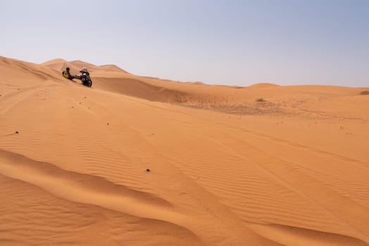 A motorbiker driving off-road in the Erg Chebbi desert became stuck in the sand, Morocco