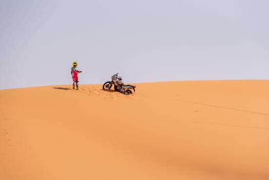 A motorbiker driving off-road in the Erg Chebbi desert became stuck in the sand, Morocco