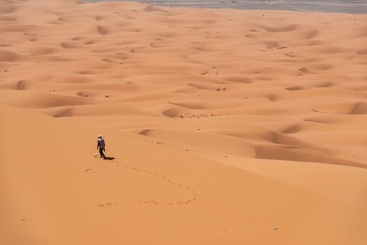 Hiking up the Great Dune of Merzouga in the Erg Chebbi desert, Moroccan Sahara desert