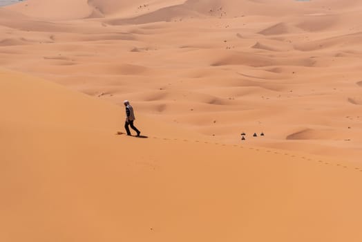 Hiking up the Great Dune of Merzouga in the Erg Chebbi desert, Moroccan Sahara desert