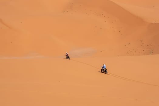 Motorbikers driving off-road in the Erg Chebbi desert near Merzouga, Morocco