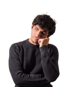 A man with curly hair wearing a black sweater, thinking, or disappointed or sad, in studio shot