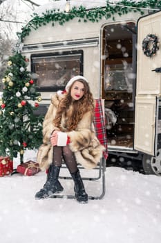 Beauty girl in santa costume with gift box at winter campsite getting ready for the new year. New year celebration concept