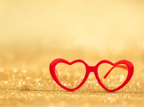 red hearts glasses on golden bokeh background