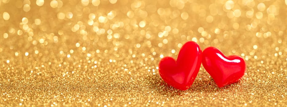 two red hearts on gold bokeh background
