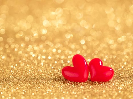 two red hearts on gold bokeh background
