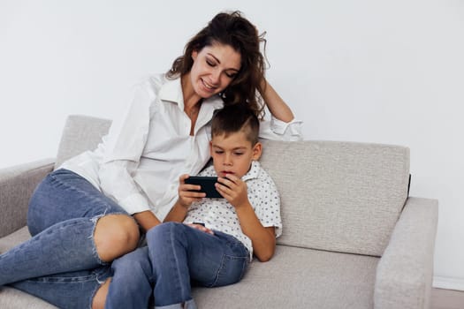 Mom and boy watching smartphone on couch