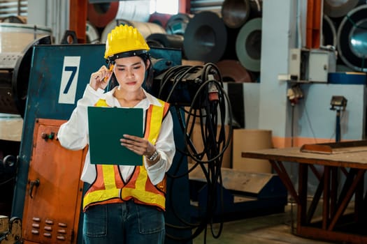 Professional quality control inspector conduct safety inspection on machinery and manufacturing process in factory. Female engineer overseeing process optimization in mechanical facility. Exemplifying