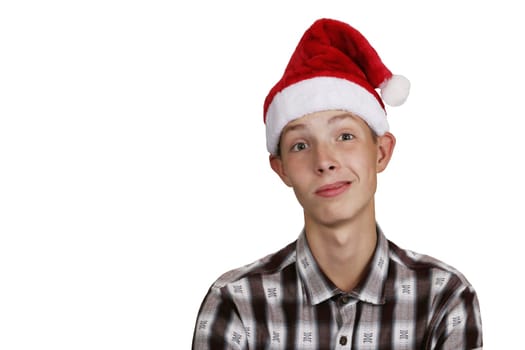 Funny, charismatic teenage boy in a shirt, wearing a Santa Claus hat, on a white isolated background. The boy makes a grimace.