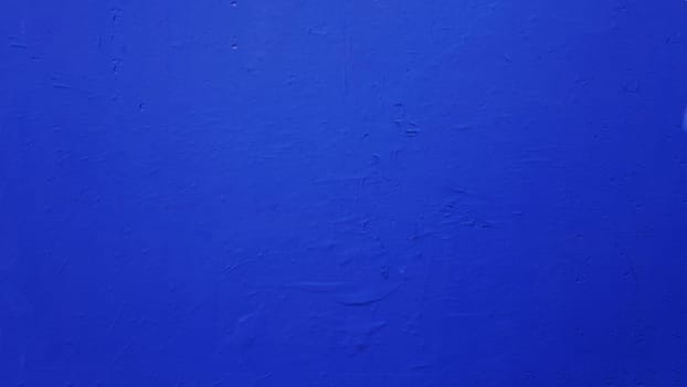Texture of a concrete wall painted in rich blue color. Grunge cement wall color blue.