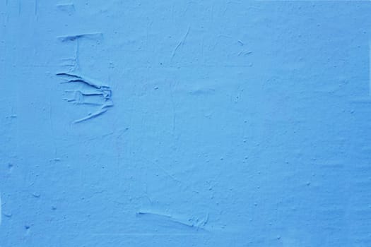 Old, time-damaged blue paint on the wall. Grunge cement wall color blue.