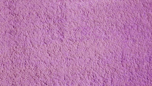 Rough concrete wall of red, purple color close-up. Plaster background.