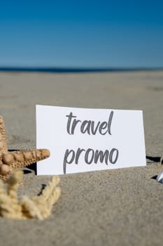 TRAVEL PROMO text on paper greeting card on background of starfish seashell summer vacation decor. Sandy beach sun coast. Holiday concept postcard. Getting away Travel Business concept