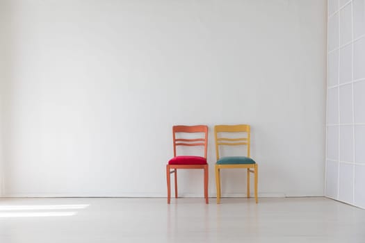 Two chairs in the interior of a white room
