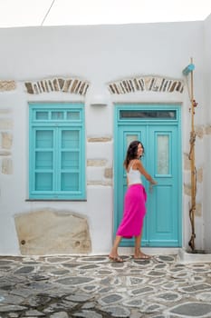 Woman in pink skirt next to an aquamarine door