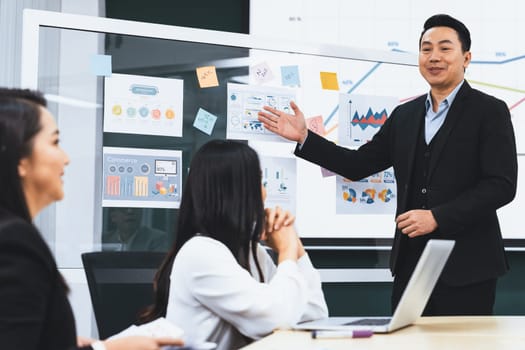 Successful businessman presenting his financial plan and data analyst with confident. group of female investors focusing on his performance intentionally. Office Conference room meeting. Intellectual.