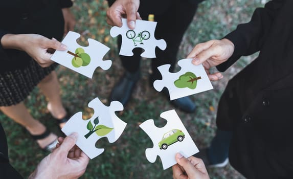 Business people or corporate partnership joining ECO friendly idea puzzle of jigsaw together as group of eco professional teamwork concept to promote social awareness on environmental protection. Gyre