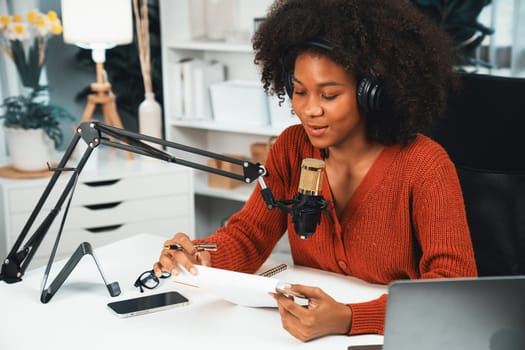 Host channel of beautiful African woman talking in online broadcast teaching marketing influencer, with listeners in broadcast or online. Concept of anywhere at work place. Tastemaker.