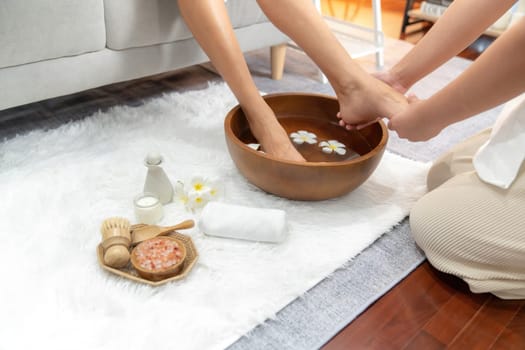 Woman indulges in blissful foot massage at luxurious spa salon while masseur give reflexology therapy in gentle day light ambiance resort or hotel foot spa. Quiescent