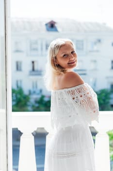 Portrait of a beautiful slender woman in a white summer knitted dress