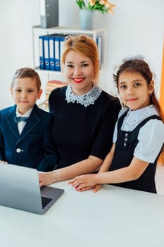 Teacher teaching kids on laptop school