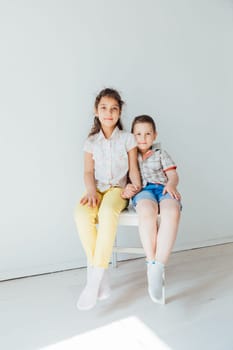 Little boy and girl sitting next to each other on the same chair