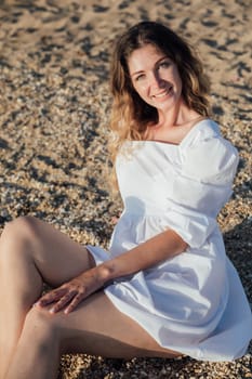 a woman in white dress on the beach on a walk