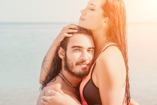 Close up shot of beautiful young caucasian woman with black hair and freckles looking at camera and smiling. Cute woman portrait in a pink bikini posing on a volcanic rock high above the sea