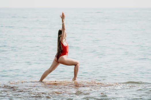 Woman sea yoga. Back view of free calm happy satisfied woman with long hair standing on top rock with yoga position against of sky by the sea. Healthy lifestyle outdoors in nature, fitness concept.