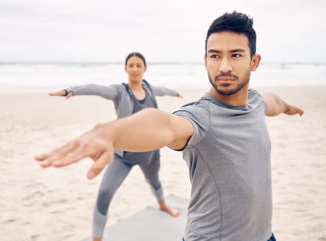 People, yoga and warrior pose on beach for fitness, exercise and holistic wellness, teamwork or workout outdoor. Couple of friends or instructor stretching with balance, health and pilates by ocean.