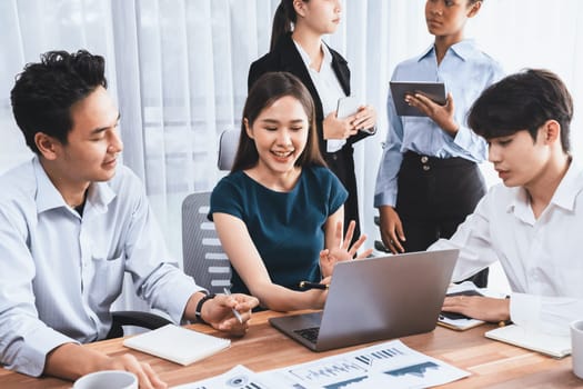 Multiracial analyst team use BI dashboard data to analyze financial report on meeting table. Group of diverse business people utilize data analysis by FIntech for success business marketing. Concord