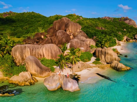 Anse Source d'Argent beach La Digue Island, Seychelles, Drone aerial view of La Digue Seychelles bird eye view. of tropical Island, couple men and woman at the beach during sunset at a luxury vacation