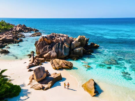 Anse Cocos beach, La Digue Island, Seychelles, Drone aerial view of La Digue Seychelles bird eye view. of tropical Island, couple men and woman walking at the beach during a luxury vacation