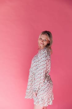 blonde woman in summer dress on pink background
