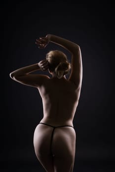 Low key portrait of beautiful female body on a dark background