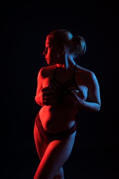 Low key portrait of beautiful female body on a dark background