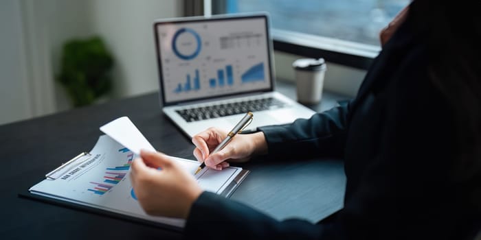 Young business woman looking at computer monitor, analyzing project statistics, marketing research results or statistics data, developing marketing strategy, working at office.