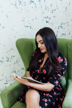 Woman with tablet sitting in an armchair in a bright room Communication Education