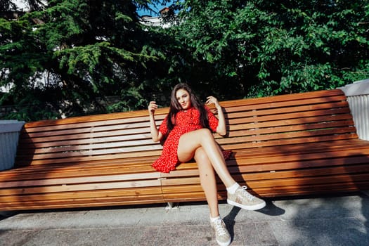 woman in red dress sitting on a bench for a walk