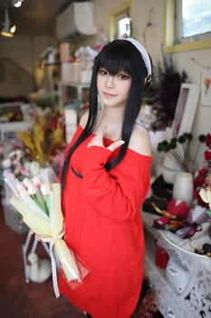 Portrait of a beautiful young woman Cosplay with red sweater at flower shop