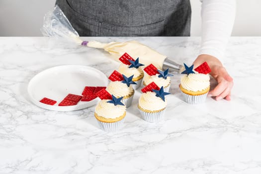 Decorating lemon cupcakes with patriotic blue chocolate star and red mini chocolate.