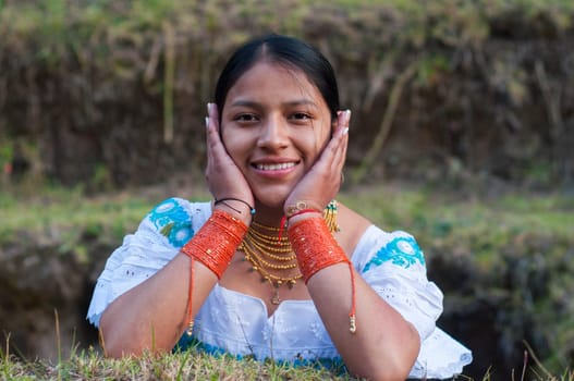 pretty indian woman looking at camera with a pretty smile and resting her head in her hands. High quality photo